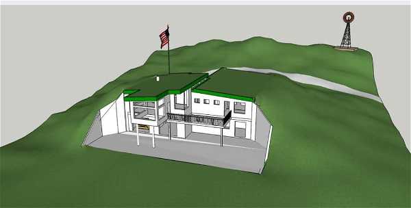 A 3D computer-generated model of a hillside house with a green roof. The house is partially embedded into the hill and has an American flag flying from the roof. In the background, there are grassy hills and a windmill. A road or